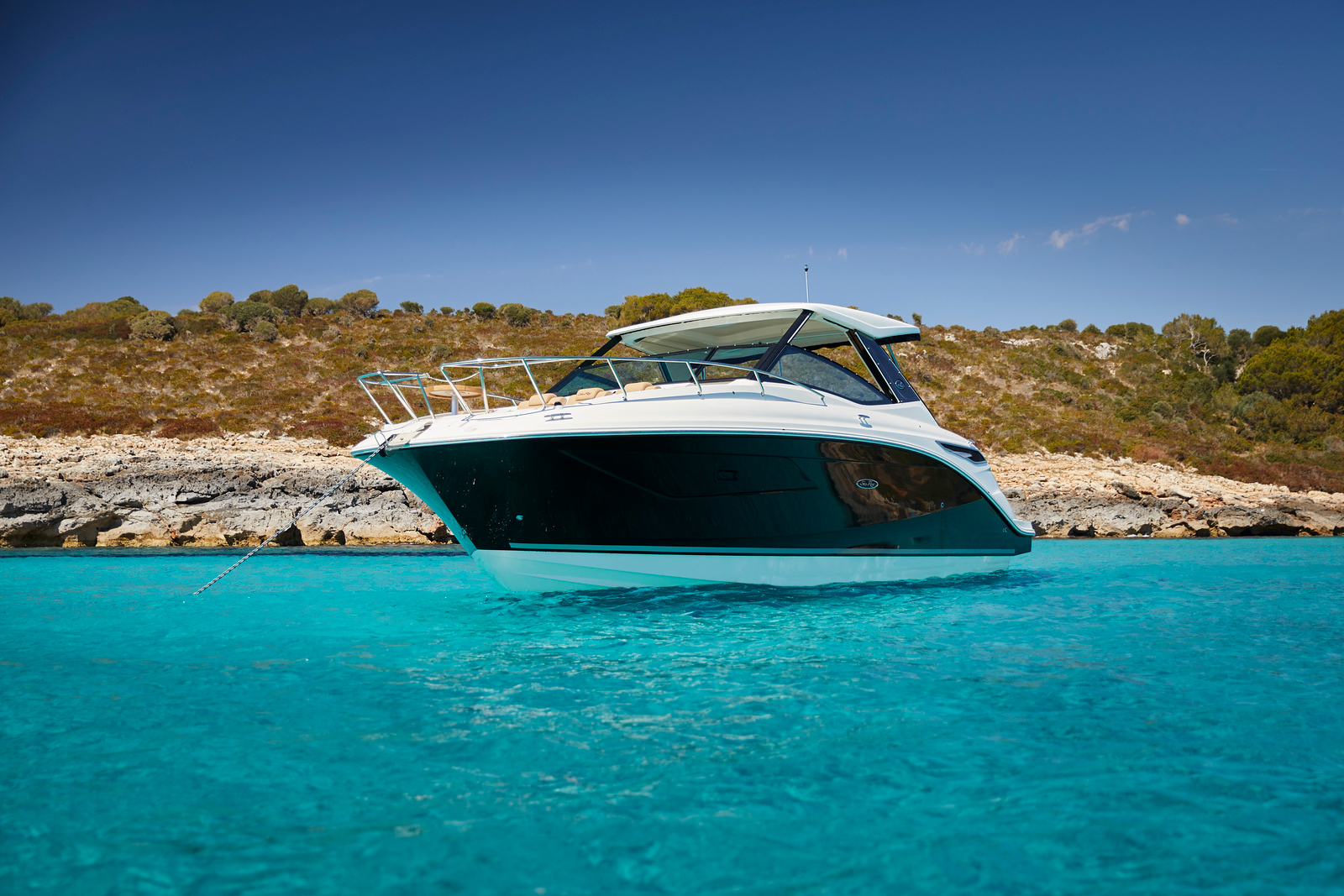 Sea Ray Sundancer 320 bow view anchored in a crystal-clear turquoise cove on the Costa Blanca