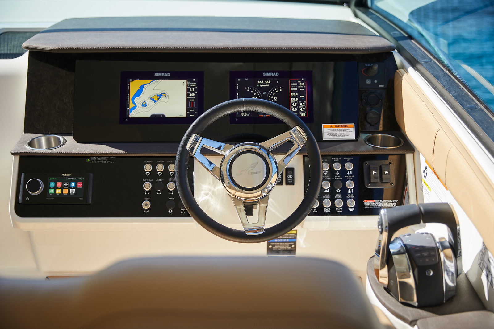 Helm station of the Sea Ray Sundancer 320 with twin Simrad displays and leather wheel